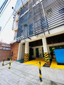 un gran edificio con letreros amarillos y negros delante de él en Happy Homes Manila, en Manila