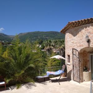 un patio con sedia e ombrellone e un edificio di French Riviera Gaudissard a Vence Altre 34 foto