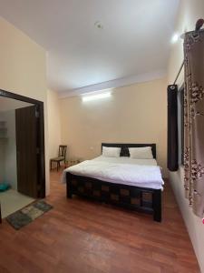 1 dormitorio con 1 cama y suelo de madera en Chirag Homestay Kainchi, en Nainital