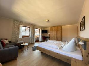 a bedroom with a large bed and a living room at Ferienhof Schlag in Waldmünchen