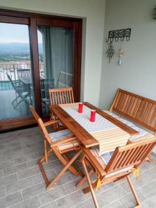 y balcón con mesa y sillas de madera. en Superbe appartement dans petite résidence ., en Badesi