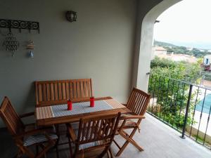 einen Holztisch mit zwei roten Tassen auf einem Balkon in der Unterkunft Superbe appartement dans petite résidence . in Badesi