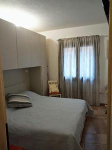 a small bedroom with a bed and a window at Superbe appartement dans petite résidence . in Badesi