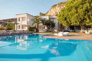 una casa con piscina frente a una casa en Princess Tia Hotel en Samos