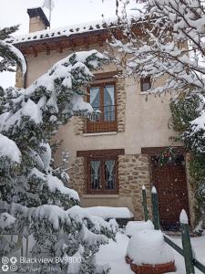 una casa cubierta de nieve delante en El Refugio de la Sauca, en Alameda del Valle