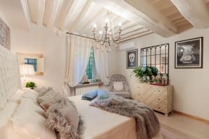 - une chambre avec un grand lit et un lustre dans l'établissement Casa Blanc, à Lucques