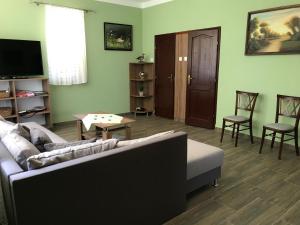 a living room with a couch and a table and chairs at Vénusz Üdülőcentrum in Tiszacsege