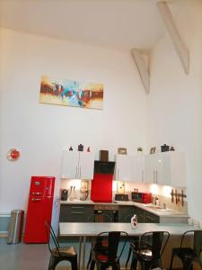 cocina con mesa, sillas y nevera roja en Superbe appartement type loft en duplex rue Buat en Châlons-en-Champagne