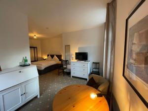 ein Schlafzimmer mit einem Bett und einem Tisch in einem Zimmer in der Unterkunft dS Hotel Restaurant Gronau in Gronau