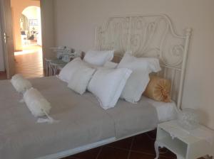 a white bed with white pillows on top of it at The Bliss Estate Exclusive in Agia Paraskevi