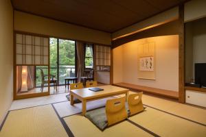 伊豆高原温泉リゾート　森の泉 في إيتو: غرفة معيشة مع طاولة وكراسي
