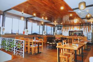 a restaurant with wooden tables and chairs and windows at Casa Nativa Iquitos in Iquitos