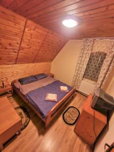 a bedroom with a bed in a wooden room at Vila Luca's in Cîrţişoara