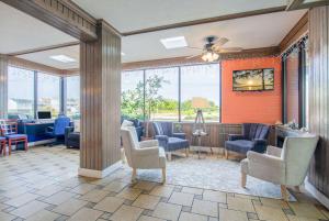a lobby with chairs and tables and windows at Travelodge by Wyndham Outer Banks/Kill Devil Hills in Kill Devil Hills