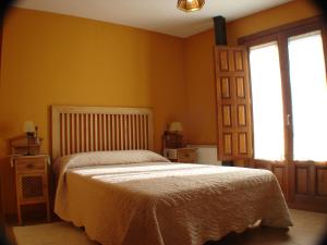 1 dormitorio con cama y ventana en El Refugio de la Sauca, en Alameda del Valle