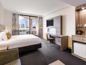 シドニーにあるSydney Central Hotel Managed by The Ascott Limitedのベッドとデスクが備わるホテルルームです。