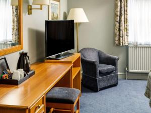 a living room filled with furniture and a tv at Mercure Bristol North The Grange Hotel in Bristol
