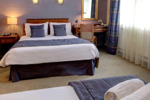 ポート・タルボットにあるBest Western Aberavon Beach Hotelの大きなベッドとデスクが備わるホテルルームです。