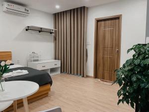 1 dormitorio con cama, mesa y planta en B786 Airport Apartment en Ho Chi Minh