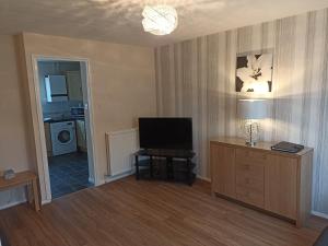 sala de estar con TV y mesa con lámpara en Comfortable Billericay Home, en Billericay