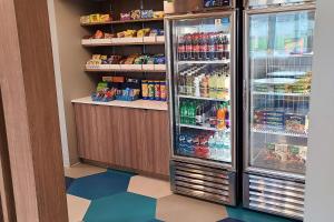 a room with a refrigerator with soda and drinks at Microtel Inn & Suites by Wyndham Milford in Milford