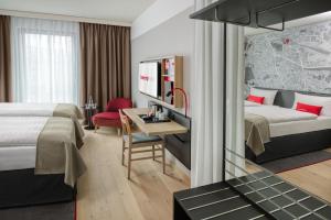ドルトムントにあるIntercityHotel Dortmundのベッドとデスクが備わるホテルルームです。