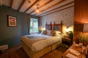 a bedroom with a large bed with a window at Castle Inn in West Lulworth