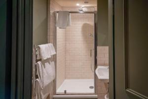 a bathroom with a shower and a toilet and a sink at Castle Inn in West Lulworth