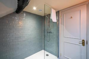 a bathroom with a shower with a glass door at Castle Inn in West Lulworth