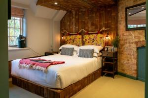 a bedroom with a large bed and a brick wall at Castle Inn in West Lulworth
