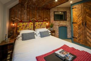 a bedroom with a large white bed and a tv at Castle Inn in West Lulworth