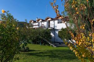 una casa blanca en una colina con un patio en La Casetta Sull'Albero 900m from the sea - Happy Rentals, en Albenga