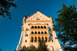 un grand bâtiment avec un ciel bleu en arrière-plan dans l'établissement Hotel Pension Schwansee, à Schwangau