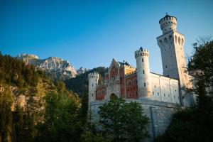 a castle with two towers on top of a mountain at Hotel Pension Schwansee in Schwangau
