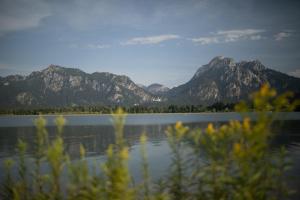 uitzicht op een meer met bergen op de achtergrond bij Hotel Pension Schwansee in Schwangau