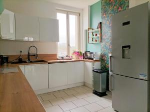 een keuken met witte kasten en een koelkast bij Magnifique duplex 3 chambres proche centre-ville et gare Chemin du Barrage in Châlons-en-Champagne