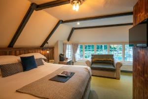 a bedroom with a bed and a couch and a window at Castle Inn in West Lulworth