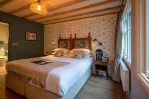 a bedroom with a large bed and a bathroom at Castle Inn in West Lulworth