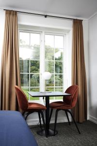 a room with a table and two chairs and a window at Hindsgavl Slot in Middelfart