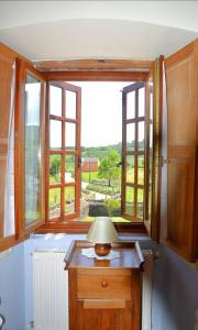 a lamp on a table in front of a window at Cabeza da Vila in San Martín de Oscos