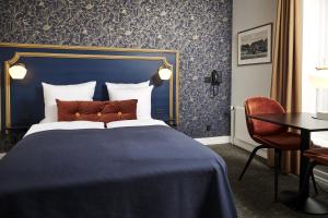 a bedroom with a large bed with a blue headboard at Hindsgavl Slot in Middelfart