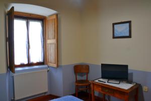 a room with a desk with a computer and a chair at Cabeza da Vila in San Martín de Oscos