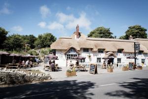 a large building with people sitting outside of it at Castle Inn in West Lulworth