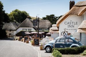 an old car parked in front of a building at Castle Inn in West Lulworth