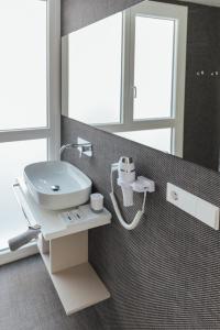 a bathroom with a white sink and a mirror at BN SUITES Teatro in Alicante +17 photos