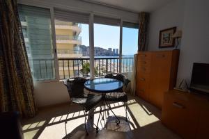 a room with a balcony with a table and chairs at Miramar Playa II- Fincas Arena in Benidorm