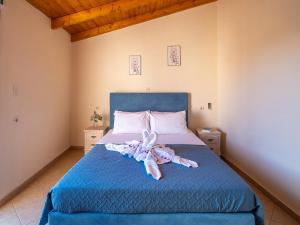 a bedroom with a blue bed with a stuffed animal on it at Villa Lucas in Melidhónion