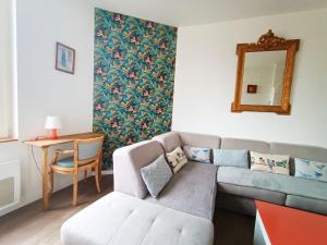 - un salon avec un canapé et un miroir dans l'établissement Magnifique appartement proche centre-ville et gare chemin du barrage, à Châlons-en-Champagne