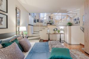 a living room with a couch and a staircase at CASA EDA, Modern Contemporary Central Apartment inside the Walls of Lucca in Lucca +18 photos