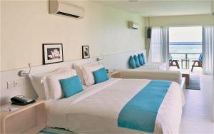 een slaapkamer met een groot bed en uitzicht op de oceaan bij Holiday Inn Resort Kandooma Maldives - Kids Stay & Eat Free and DIVE FREE for Certified Divers for a minimum 3 nights stay in Guraidhoo